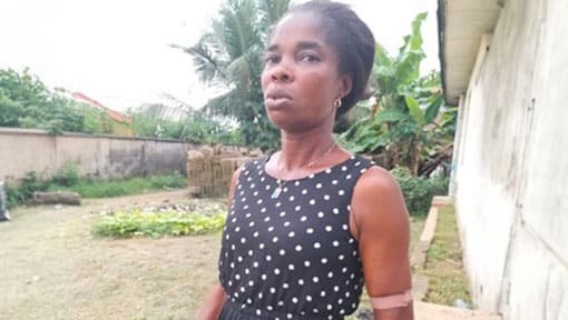 Elizabeth Sunday standing outside in her community. 